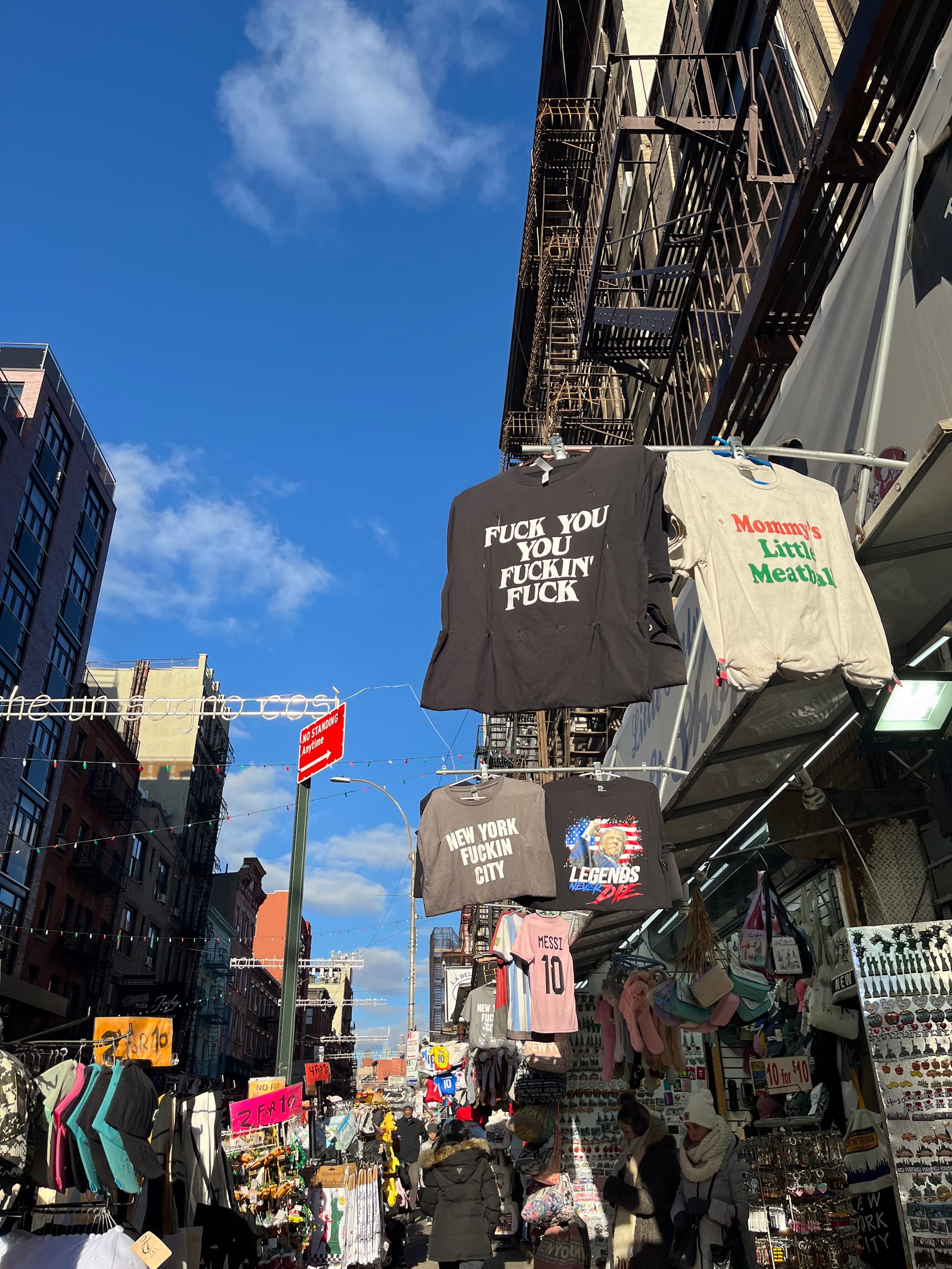 T-shirts with obscenities printed on them hanging outside shops in Chinatown.