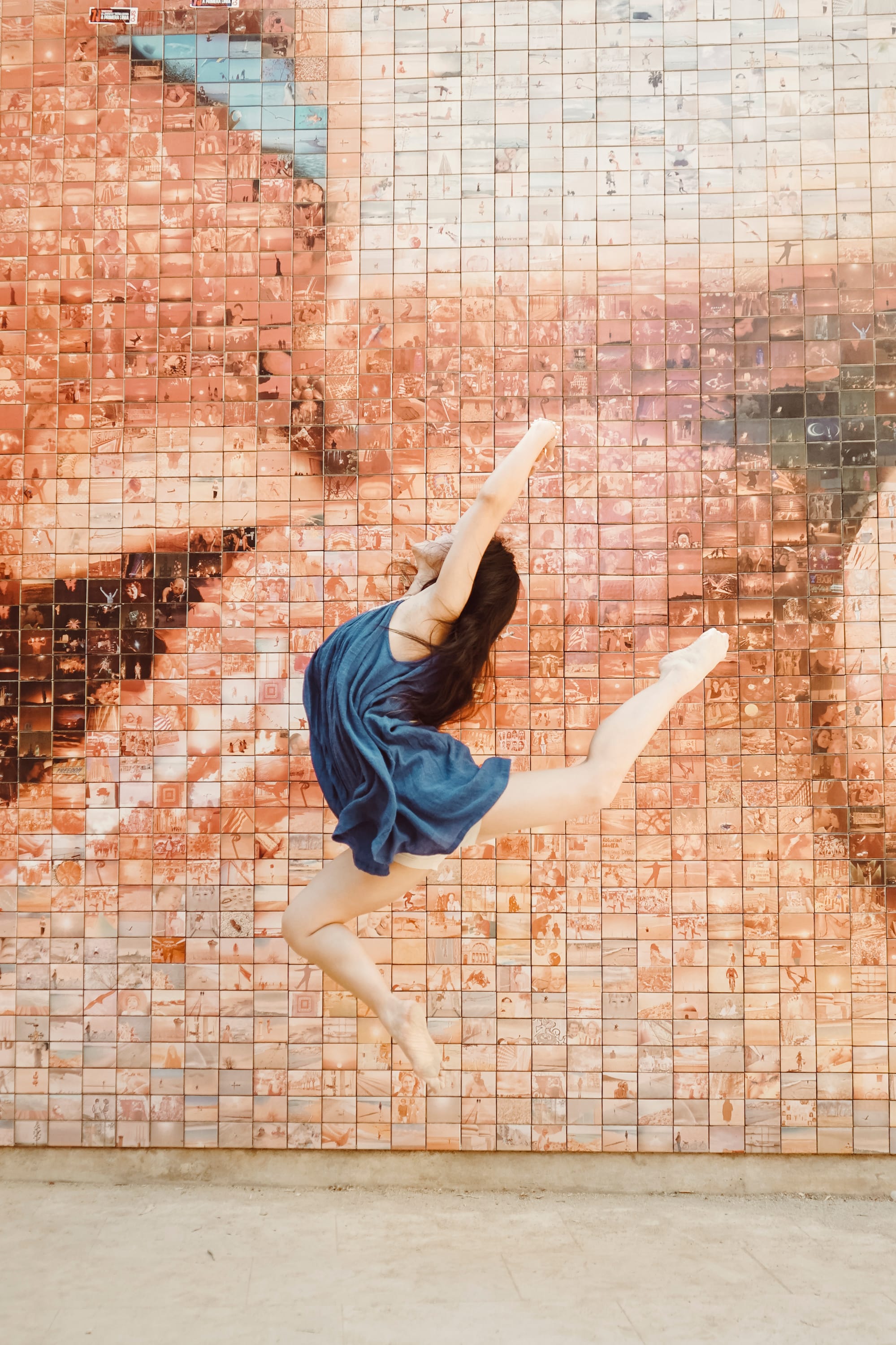girl leaping in dance pose in front of kiss mosaic.