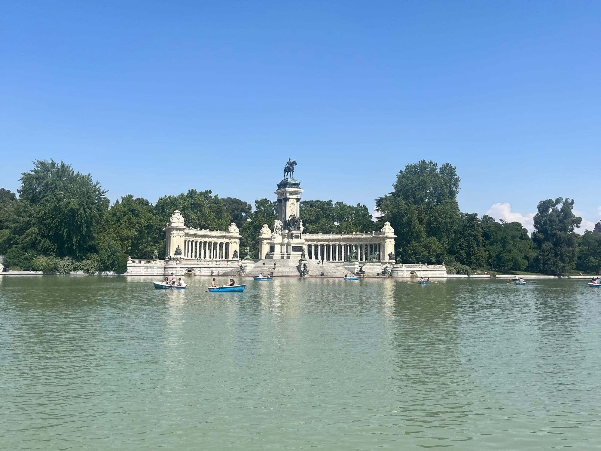 huge pond with a monument in the centre and boats on water