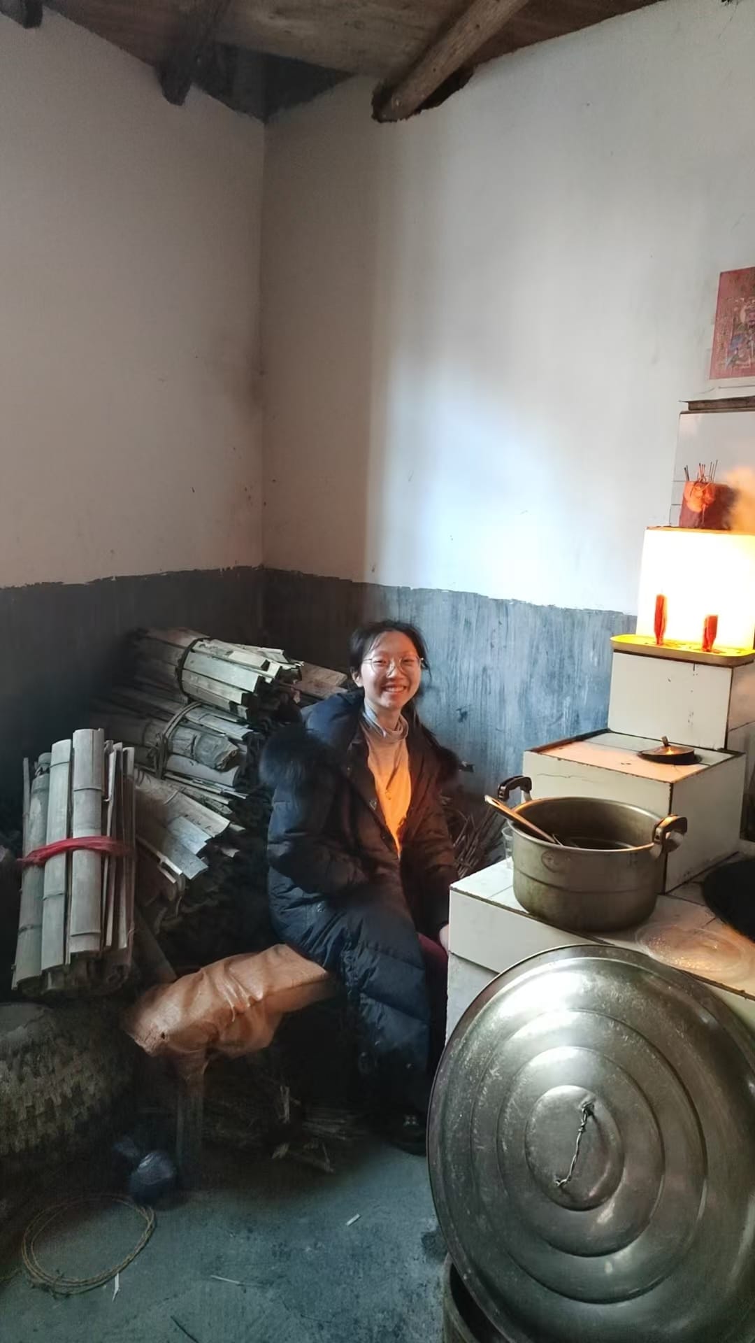 girl sitting in front of a wood stove, smiling